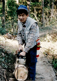 間伐材や風倒木をチェンソーで切る相川さん