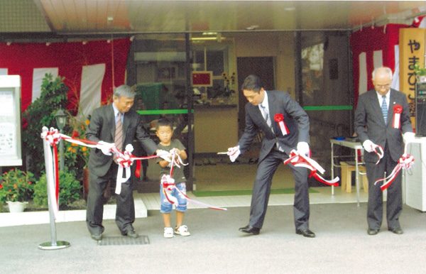 新しい施設の開所式でテープカットする田村さん（左）